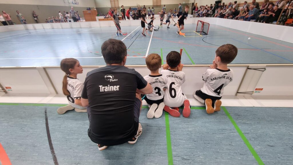 Karower Dachse sitzen am Floorballspielfeldrand